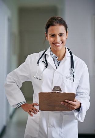 Smile, woman and portrait of doctor with clipboard in hospital reading medical data or information. Happy, checklist and female healthcare worker with charts, notes or research in medicare clinic.の写真素材