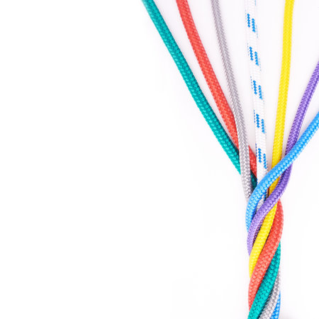 Rope, ties or connection of colorful knot or braid on white background in studio for security. Tools, cords and abstract unity of rainbow society with texture together for hiking, climbing or safetyの写真素材