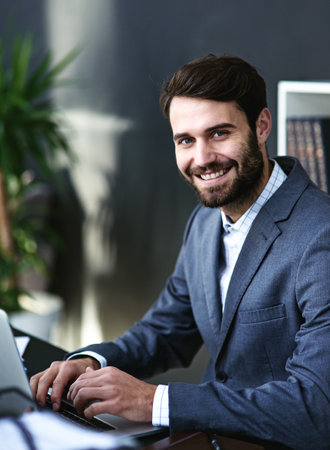 Man, portrait and lawyer with laptop for legal advice, research or corporate attorney at office. Businessman, consultant or advisor with smile on computer for case or project at law firm or workplaceの写真素材