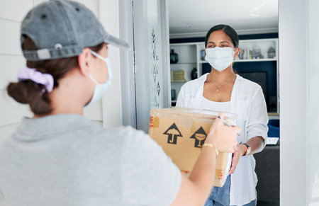 Delivery, women and home with boxes, mask and courier with safety regulations and doorway. People, employee and customer with cardboard package or parcel with virus policy or face cover with shippingの写真素材