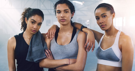 Girl, friends and portrait in gym for fitness on break with sweat, confidence and empowerment for health. People, women and group in wellness club with solidarity for workout, exercise or trainingの写真素材