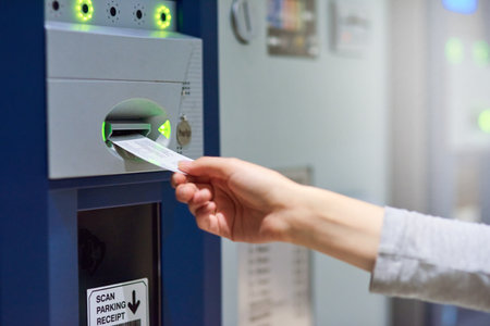 Parking lot, ticket and hand with meter machine for payment, cost and access for security, safety or garage space compliance. Exit, charge or driver with vehicle permit pass for toll, barrier or feesの写真素材