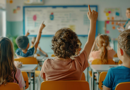 Back of students, classroom and raise hands for questions, education or learning with creative quizの素材