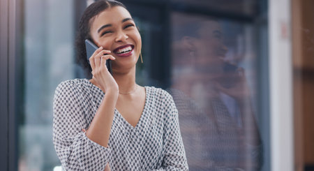 Happy woman, window and business with phone call for discussion, communication or chat at office. Female person or creative employee talking on mobile smartphone with smile in conversation or startupの写真素材