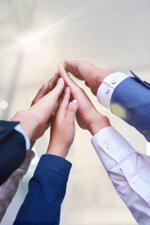 Hands, high five and success with business people in office from below for support, teamwork or unity. Goals, partnership and team building with employee group in workplace for celebration of targetの写真素材