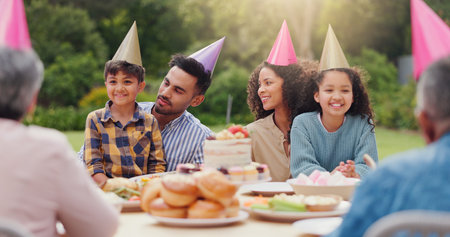 Parents, children and happy with birthday cake in garden with care, love and bonding with food at...
