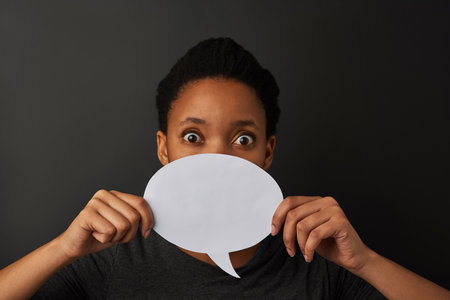 Portrait, studio and speech bubble with mockup, opinion and sign for voice and review. Person, question and idea for poll, presentation and social media expression or announcement on grey backgroundの写真素材