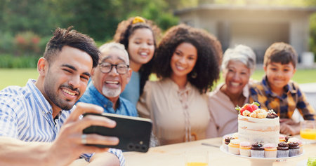 Selfie, family and birthday in backyard with happy, social media and grandparents outdoor. Home, smile and table with celebration and party cake in garden with parents and kids with love and foodの写真素材