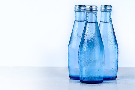 Bottles of water, studio and mineral liquid for aqua, cold drink and clear or pure tonic for diet. Natural, drink and beverage on white background for nutrition, h2o and collection for hydrationの写真素材