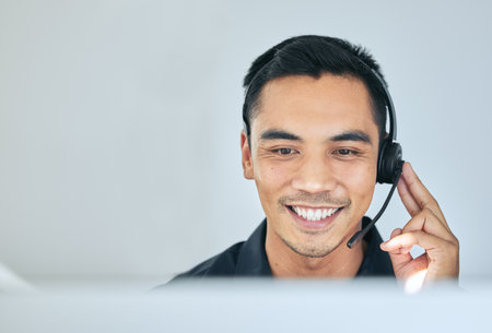 Consulting, phone call and man in office for customer service, telemarketing and headset at callcenter. Happy advisor, salesman or virtual assistant in client care, tech support or help desk for crmの写真素材