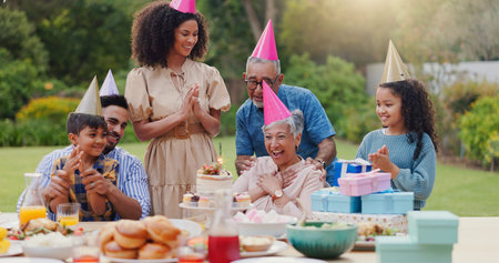 Family, clapping hands and happy with hat at birthday party for celebration, surprise or sparkler in...