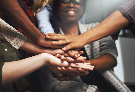 Diversity, office and hands for synergy with happiness for celebration on deal, teamwork and collaboration. People, boardroom and smile for business achievement, congratulations and team buildingの写真素材