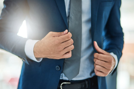 Fashion, hands and suit with business man closeup in office for ambition or start of work day. Company, corporate and getting ready in formal clothes with employee at workplace for job opportunityの写真素材