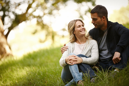 Couple, embrace and outdoor marriage on grass, together and love in relationship or bonding in park. Happy people, support and hug on holiday or vacation in nature, relax and commitment on dateの写真素材