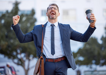 Mature man, success and excited in city, travel and professional for career win or deal in outdoors. Male person, fist pump and cheering in urban town, employee and celebrate for sale or achievementの写真素材