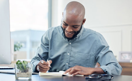 Businessman, office and notebook with smile with writing for planning with creative project. Strategy, accounting and records for corporate clients with schedule, entrepreneur and technology at deskの写真素材