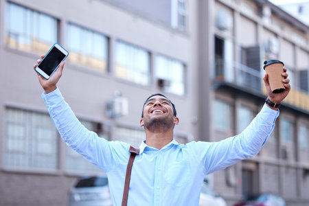 Businessman, excited and celebration in city with phone for hiring, interview success and salary increase. happy male banker, mobile and achievement in town for victory with work deal and promotionの写真素材