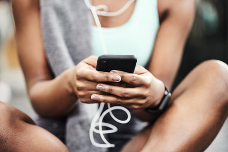 Hands, exercise and woman with smartphone, fitness and listen to music with break, relax and contact. Closeup, person or girl with cellphone, mobile user and connection with workout or check progressの写真素材