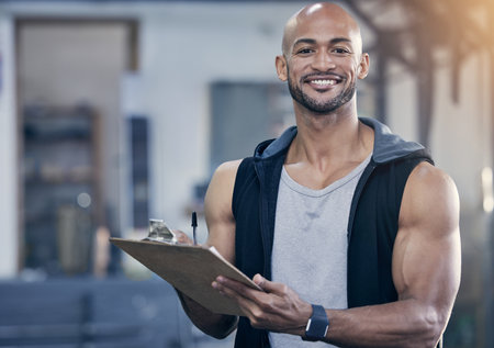 Man, clipboard and portrait in gym with writing notes for client appointment, strong body and training job. Personal trainer, paperwork and admin in wellness club for fitness business and bald workerの写真素材