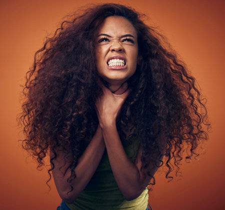 Woman, hair and angry with strangle in studio on brown background for damage, treatment and bad result. Female person, isolated and upset or disappointed at style with stress, unhappy and frustratedの写真素材