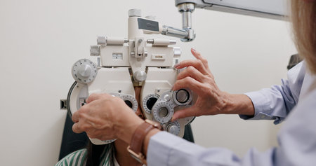 Eye care, medical and child in clinic, test and hand of specialist, phoropter or refractor for girl....