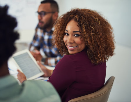 Startup, portrait or woman with tablet in meeting or discussion for brainstorming, review or partnership. Teamwork, agency and proud designer in workplace for planning, feedback and project briefの写真素材