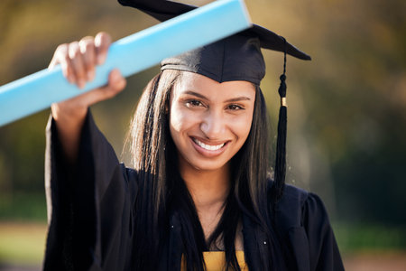 Graduation, excited and portrait of woman with degree on university campus for education achievement. Happy, future and female student graduate with college diploma, scroll or certificate with pride.の写真素材