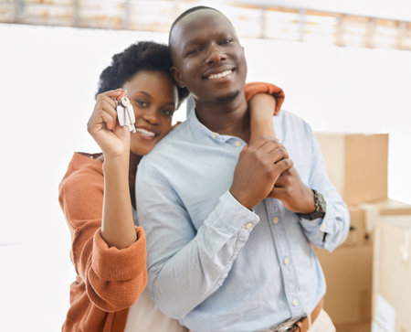 Black couple, keys and boxes with new home, love and hug in living room of house for living together. Romance, smile and mortgage with man and woman in apartment for future investment opportunityの写真素材