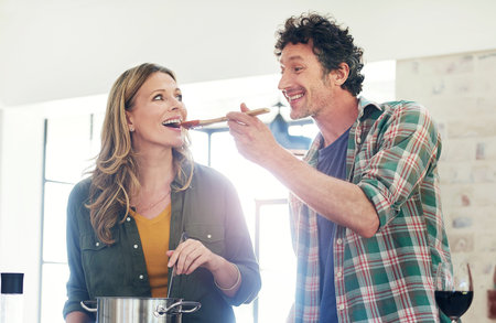 Mature, couple and taste or cooking in kitchen with sauce test, meal prep and dinner in home with...