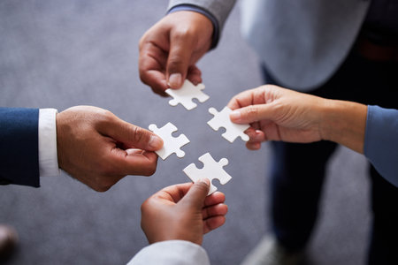 Businesspeople, collaboration and puzzle with hands in office for teamwork or synergy with joint effort. Group, corporate and partnership with unity in company or trust with employees in Germany.の写真素材
