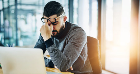 Businessman, eye strain and headache for stress with laptop in office with burnout, tired and...