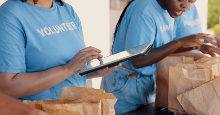 People volunteering, tablet and food donation in community service, poverty support and NGO...