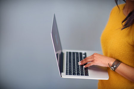 Studio, mockup and hands of person with laptop for ecommerce, typing email and web information. Backdrop, electronic user and computer for digital search, connection and technology by gray backgroundの写真素材