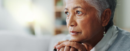 Elderly woman, closeup and thinking with cane for mental health, retirement and healthcare at nursing home. Senior person with disability, walking stick and sad on sofa for arthritis or dementiaの写真素材