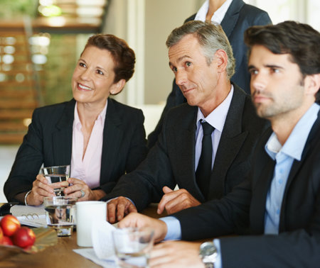 Business people, teamwork and collaboration in office for meeting, discussion and deal negotiation. Corporate, colleagues or employees in boardroom together for contract, review and plan feedbackの写真素材