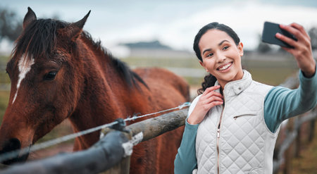 Smile, woman and selfie at horse farm outdoor for social media, internet or jockey blog for photography in nature. Happy, person and picture with equestrian animal in countryside field for influencerの写真素材