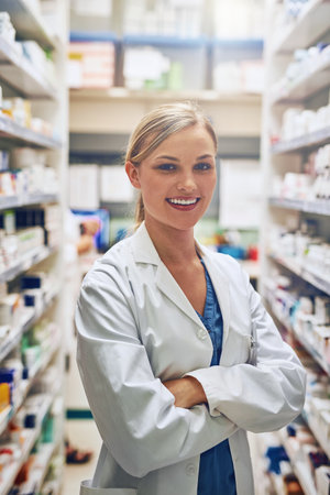 Intern, pharmacy or portrait of happy woman with arms crossed or pharmacist in healthcare clinic or drugstore. Trust, smile or proud medical worker by shelf for pills medication or medicine to helpの写真素材