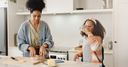 Mother, child and packing sandwich for school lunch or preparing in home kitchen, morning or student. Woman, daughter and breakfast drink in apartment or nutrition meal for education, snack or healthの写真素材