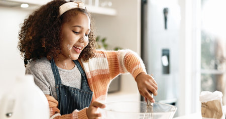 Girl, baking and mixing in home kitchen or batter, house and motor skills or childhood development for culinary education. Cooking, cookie dough and happy dessert, bowl and ingredients with utensilsの写真素材