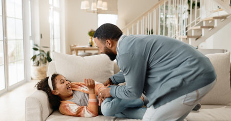 Father, child and laughing for tickle game on home sofa or parenting bonding, happiness or childhood. Man, daughter and living room connection or love affection in apartment, family house or humorの写真素材