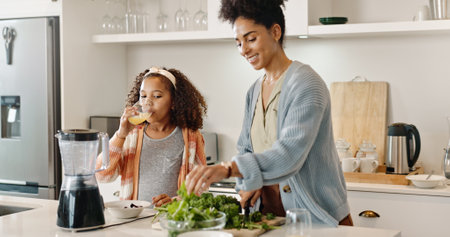 Kitchen, mother and girl with juice, cooking and bonding for breakfast, smile and love for daughter. Home, woman and teaching of meal prep to child, care and relax in apartment, together and happyの写真素材