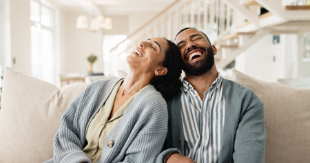 Happy couple, laughing and couch for funny joke or humor bonding in home, marriage or living room. Man, woman and relationship conversation or apartment relax with partner or together, house or chatの写真素材