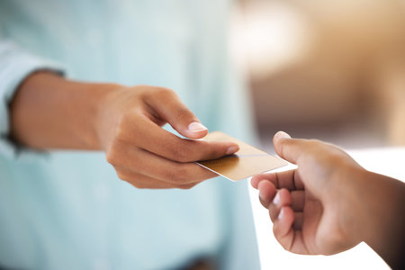 People, hands and giving credit card for payment, transaction and shopping at retail shop in city. B2c, customer or client with financial exchange for services with offer at point of sale or bankingの写真素材