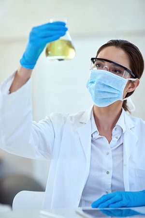Woman, scientist and chemical in glass for scientific experiment, reaction and research. Healthcare, mask and test tube with medical study or innovation for vaccine, cure and sample for medicineの写真素材