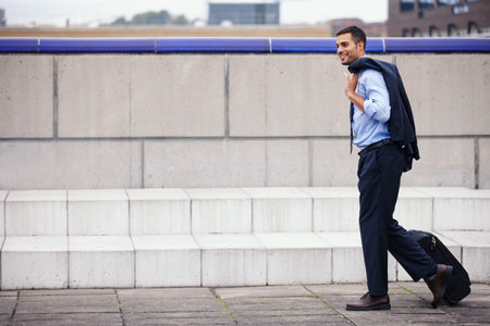 Happy, businessman and walking with luggage for morning commute to work on urban street or sidewalk. Smile, male person or employee and travel with formal suit on city pavement for running to meetingの写真素材