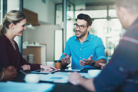 Business people, collaboration and meeting with discussion in boardroom for finance project and investment planning. Professional, teamwork and employees with tablet, paperwork or strategy with ideasの写真素材