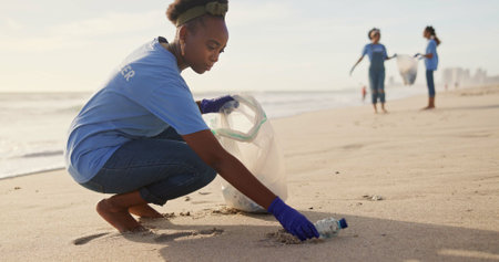 Volunteer, beach or woman with plastic, bottle or bag in nature for sustainability, help or ocean cleaning project. Accountability, team or friends at sea for earth day, social responsibility or NGOの写真素材