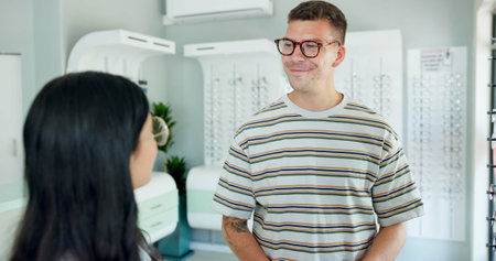 Consultation, optometrist and customer at store for glasses, eye health and wellness at shop. Ophthalmology, lens frame and woman help happy man for spectacles choice, vision and eyesight correctionの写真素材