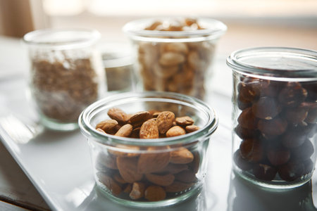 Bowls, nuts and seeds on plate, kitchen and hazelnut for nutrition, health and table with diet for...