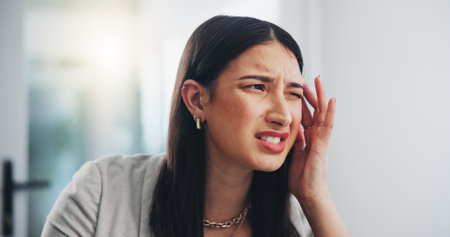 Business, stress and woman in office, headache and pain with burnout, overworked and fatigue in workplace. Person, agent and employee in migraine, frustrated and crisis with emergency and brain fogの写真素材
